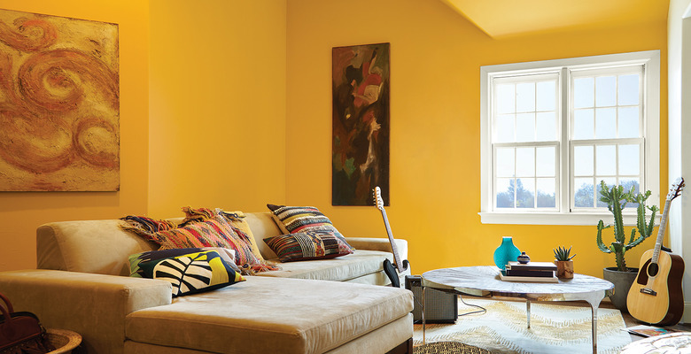 yellow family room paint colors with sectional couch and circle coffee table