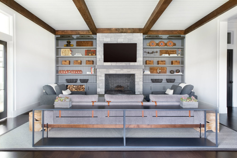 family room with fireplace and TV layout with built-in bookshelves and exposed wood beams