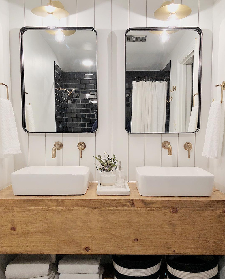 farmhouse bathroom lighting with brass fixtures over wood vanity with vessel sinks