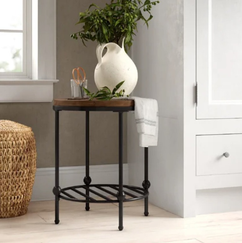 Round end table with wood top and metal legs.