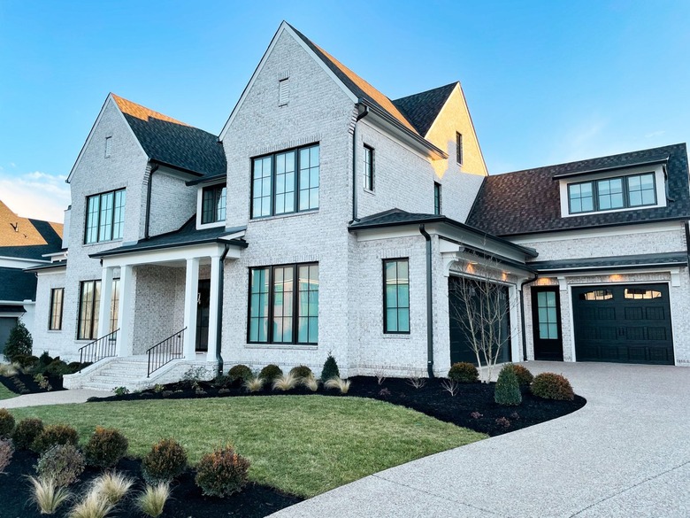 brick farmhouse exterior with black garage door