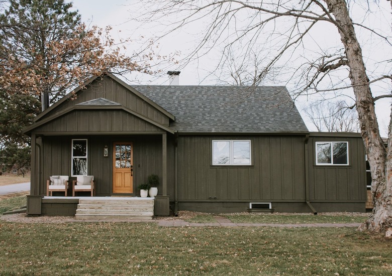 dark green farmhouse exterior with wood door