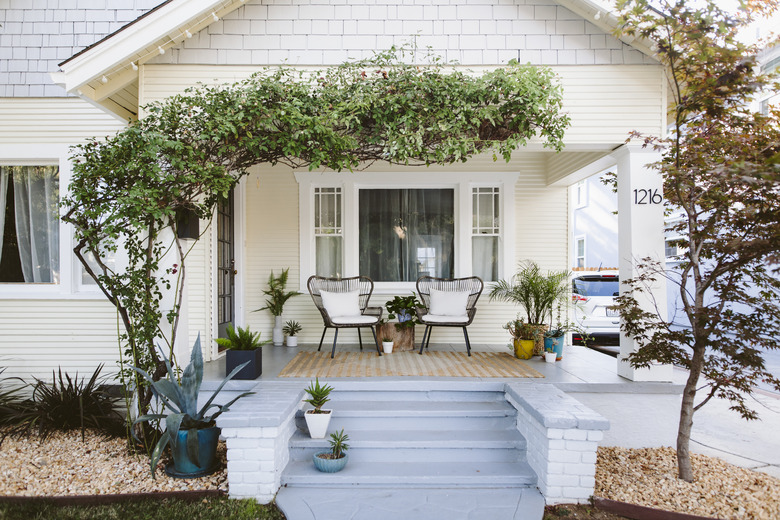 front porch of house with blue steps and two chairs