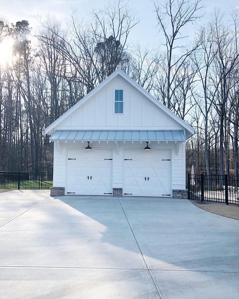 Farmhouse garage doors with barn-style details and white exterior