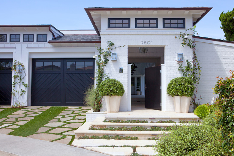 Farmhouse garage doors in black chevron design and white brick exterior