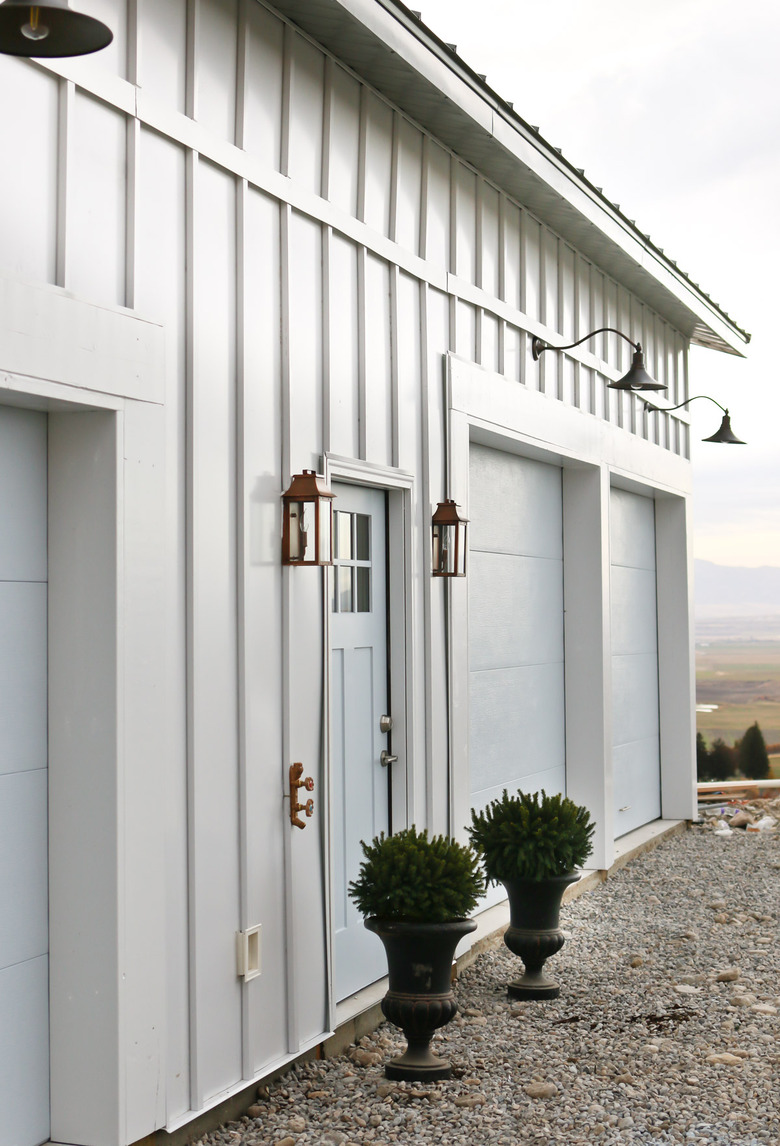 light blue farmhouse garrage doors with barn-style lighting