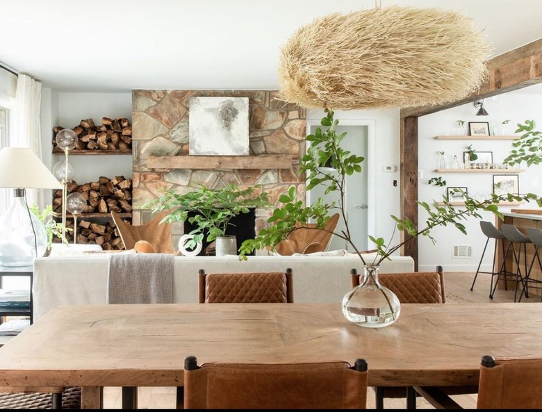 living room with stone fireplace and woven pendant light