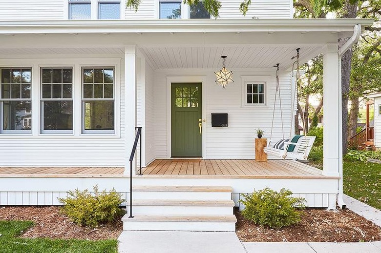 white home with green front door and minimal decor.