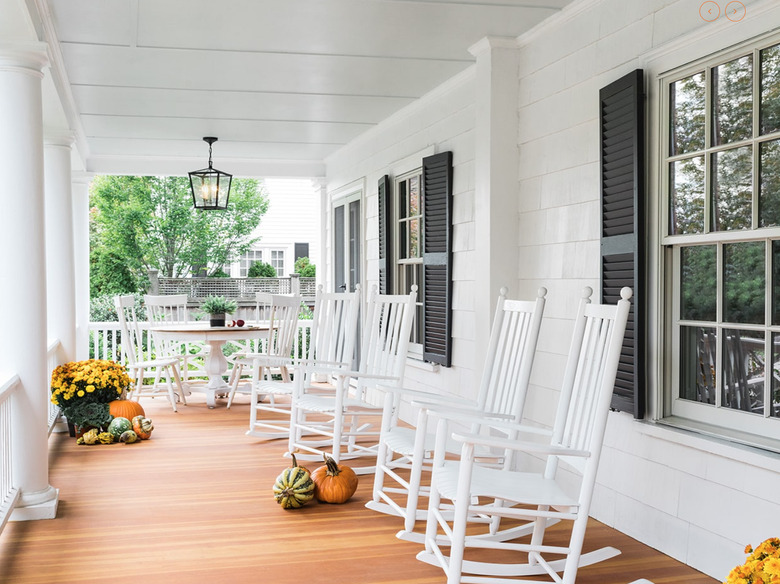 farmhouse porch idea with white rockers and fall decor