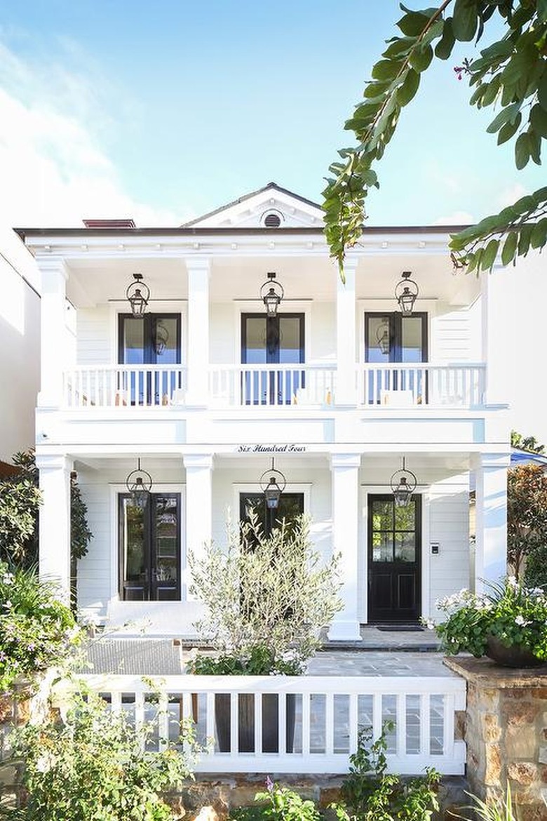 white double porch with black trim and series of windows