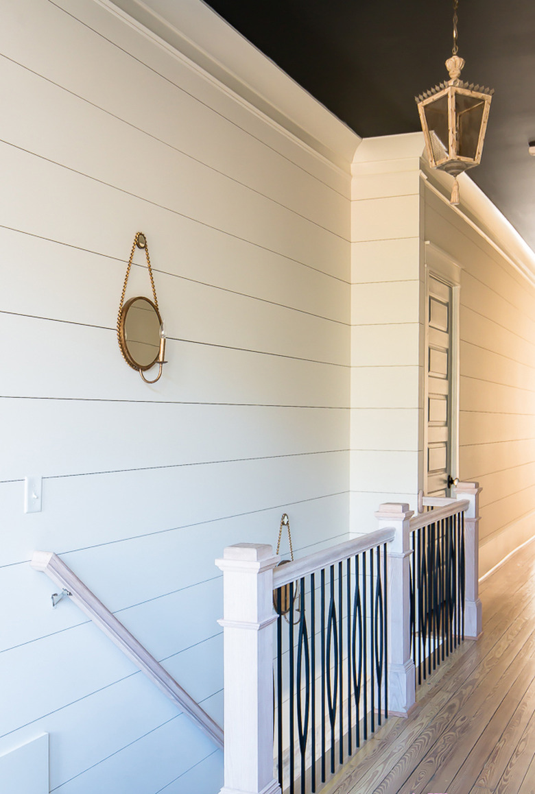 Black wrought iron farmhouse stair railing with white shiplap wall