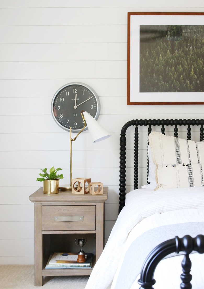 bedroom with antique bed frame and shiplap wall