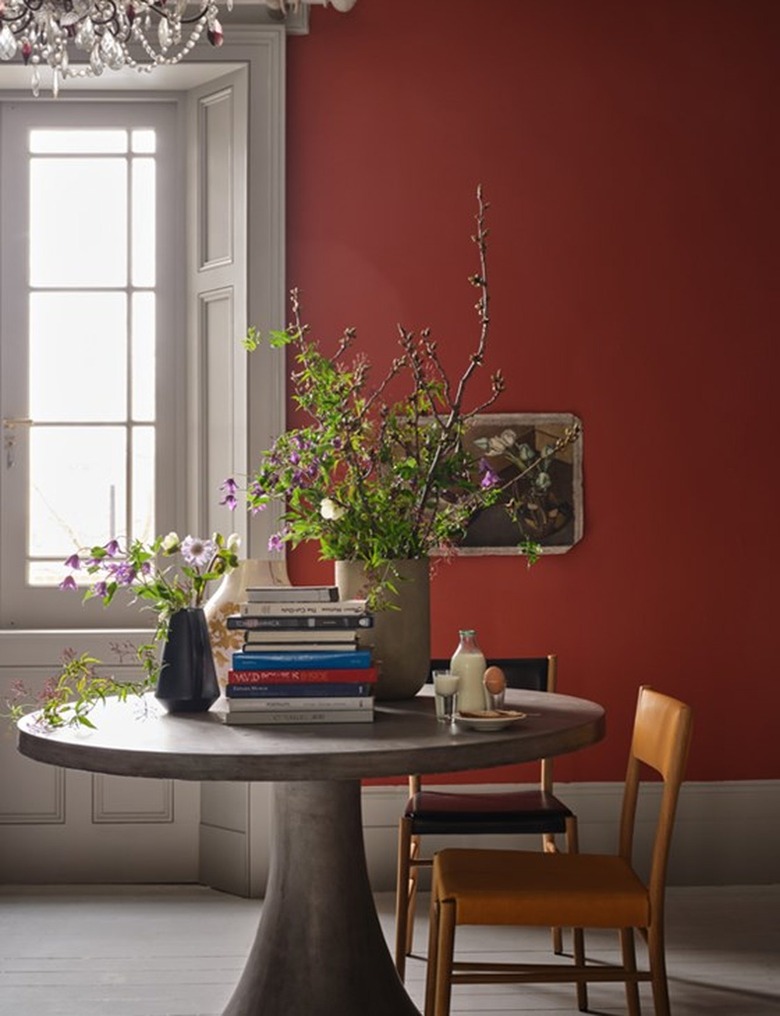 Farrow & Ball's red paint color on a wall behind a dining table and two chairs.