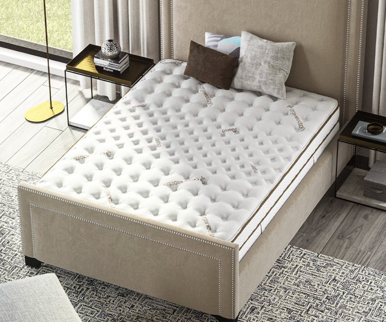 Saatva Classic Mattress on a tan bed frame in a bedroom