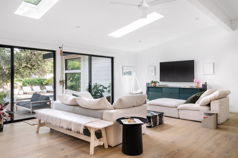 white living room with floor to ceiling windows and sofas