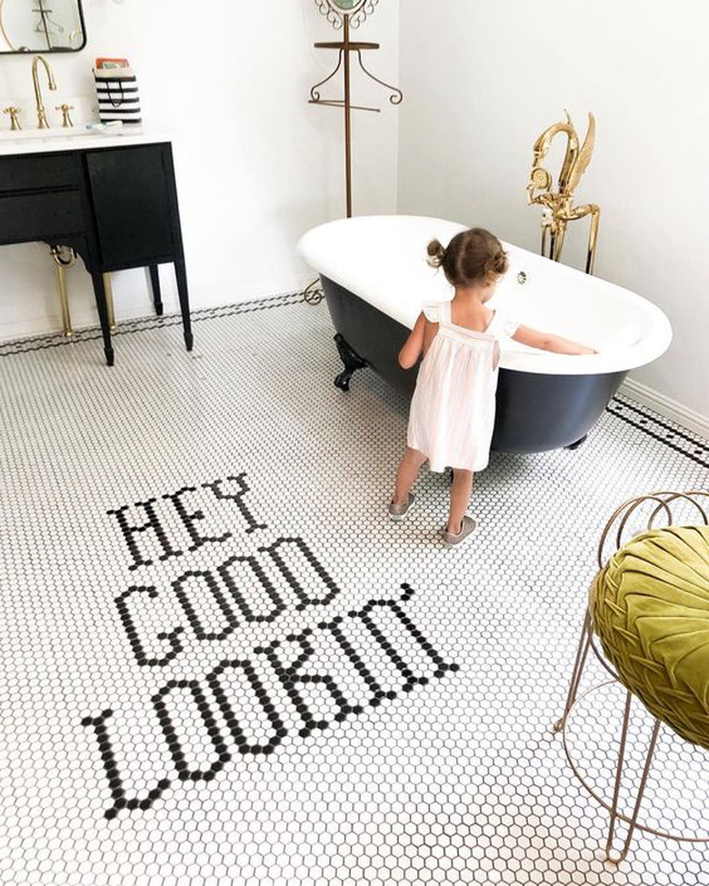 bathroom with black clawfoot bathtub and black vanity cabinet