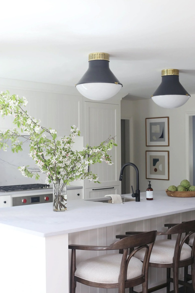 white kitchen with two gray and brass flush mount light fixtures