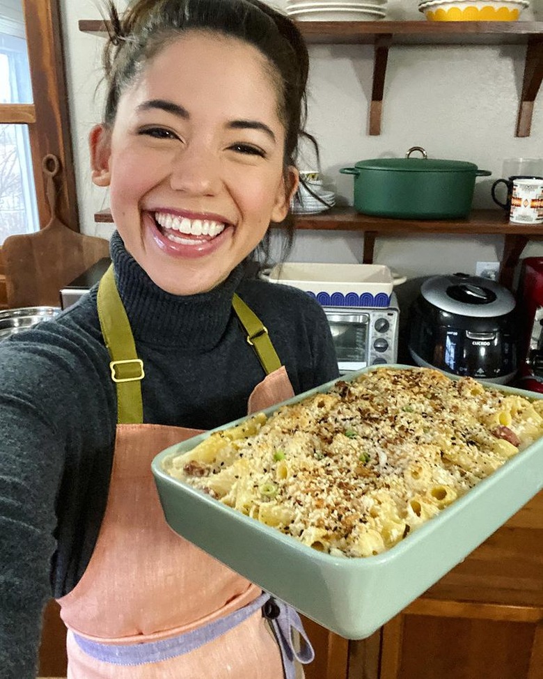 Molly Yeh of my name is yeh holding everything bagel mac and cheese