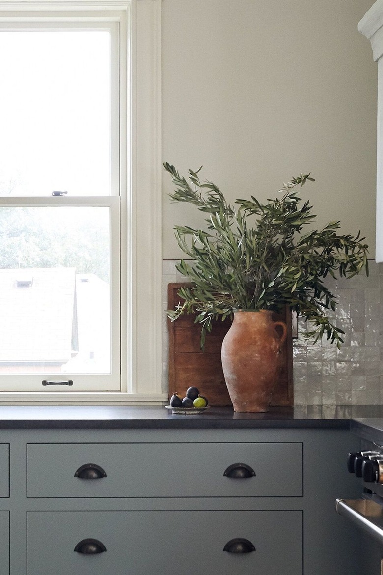 neutral kitchen with gray cabinets and large vase of flowers