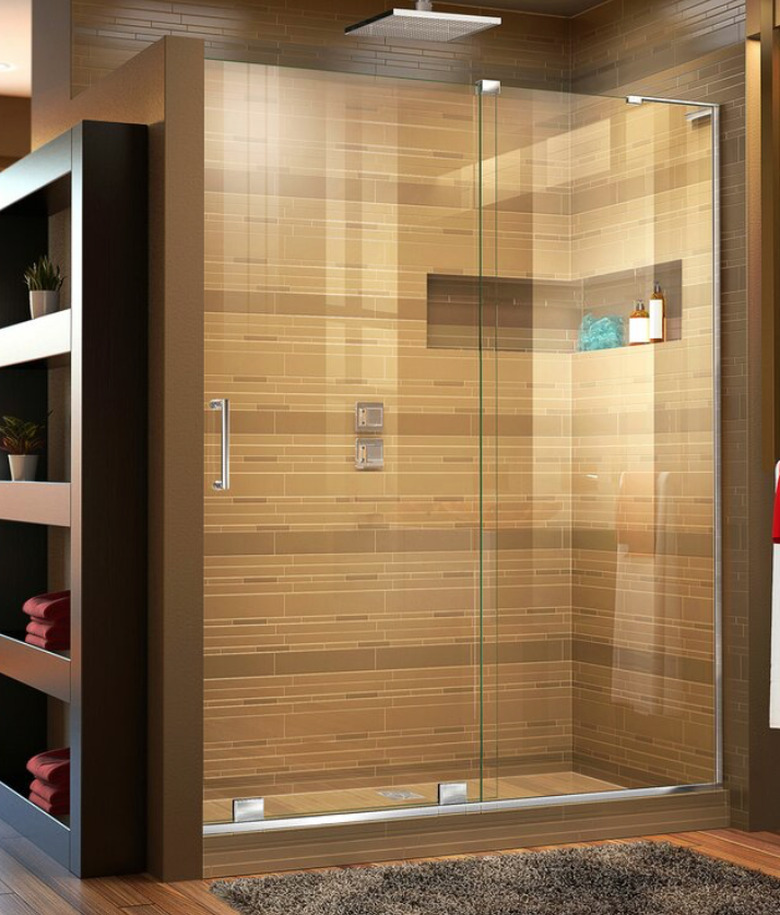 Brown and gold tiles in large modern shower with frameless shower door.