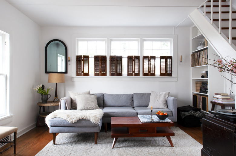 living room with midcentury coffee table, white walls, bookcase