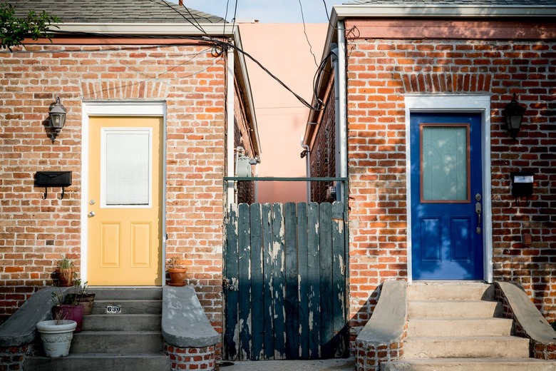 red brick home exterior with colorful front doors