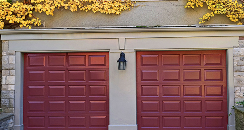 Dark red garage door colors on stone house.