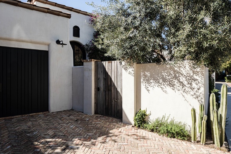 White Mediterranean style home with terra-cotta roofing and a wood door