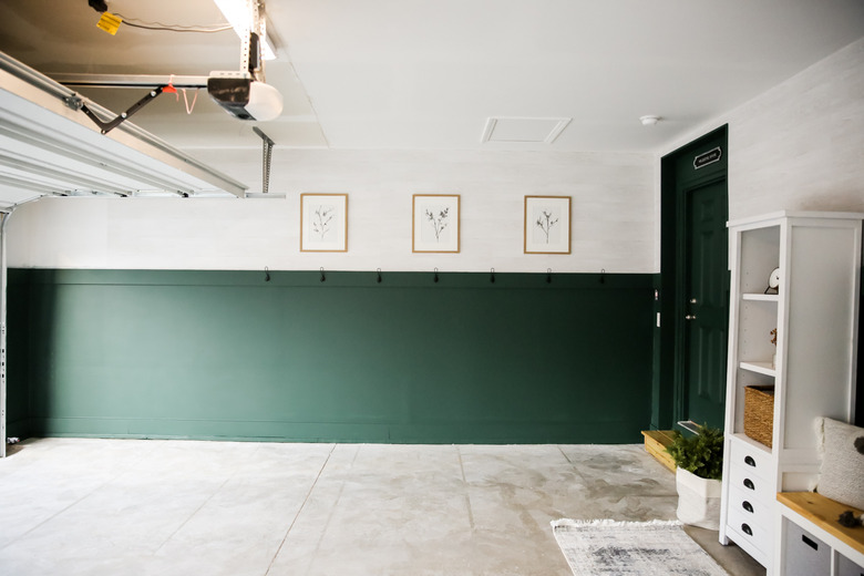 converted garage mudroom with hooks and bench area