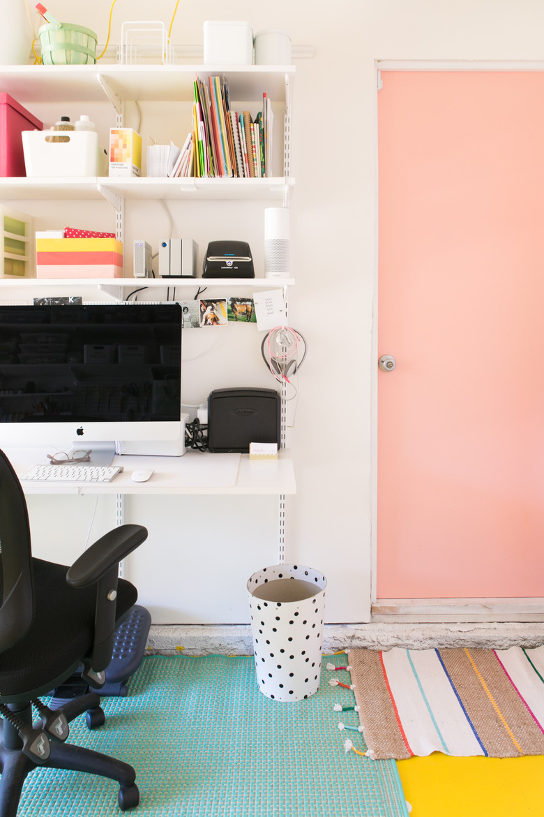 Garage office with pink door and computer on desk