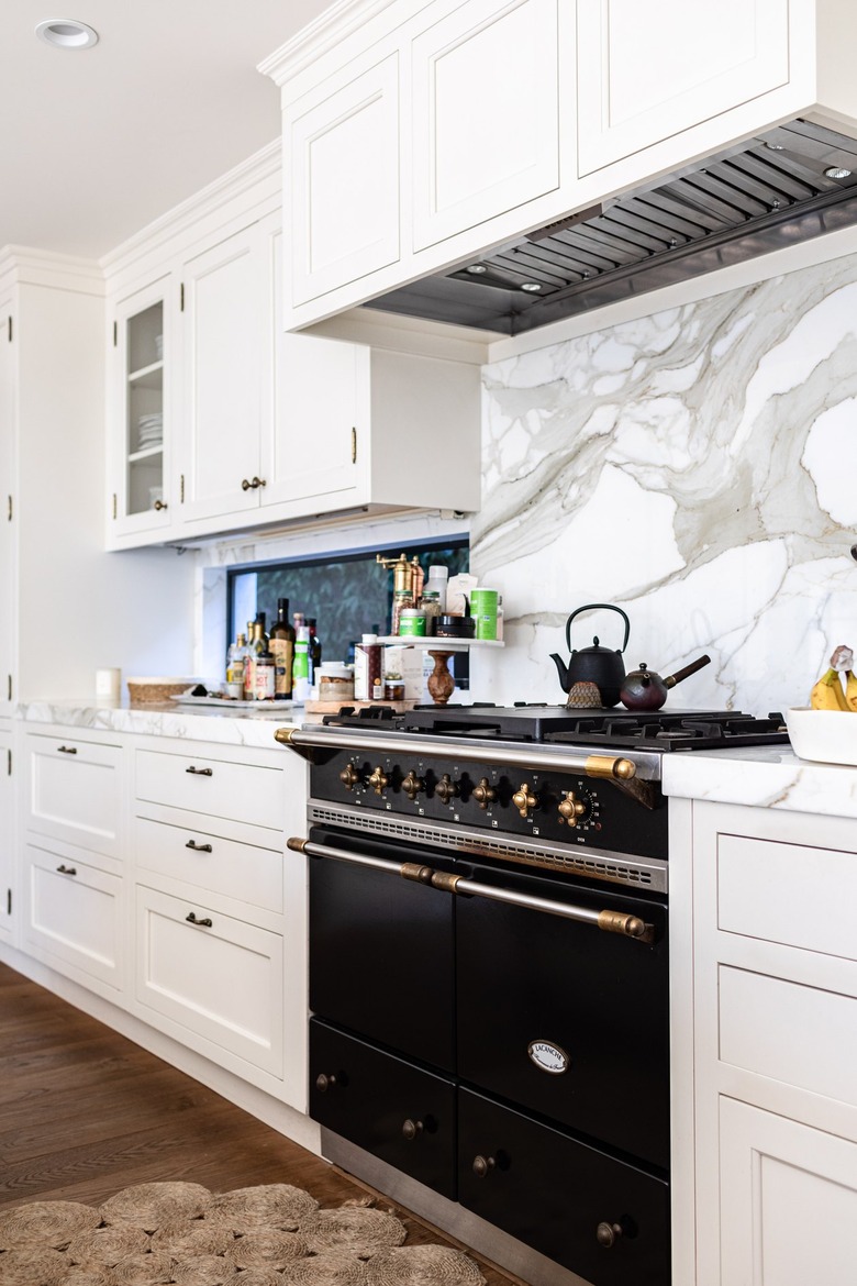 black stove with gas stovetop and marble backsplash