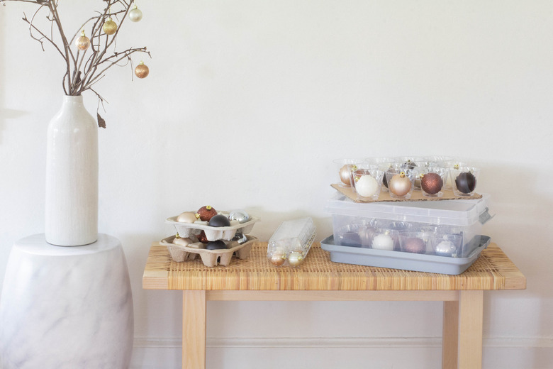 Ornaments stored inside plastic cups, drink holders and egg cartons