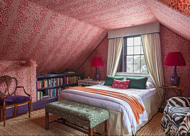 bold red and pink patterned bedroom with drapery over bed