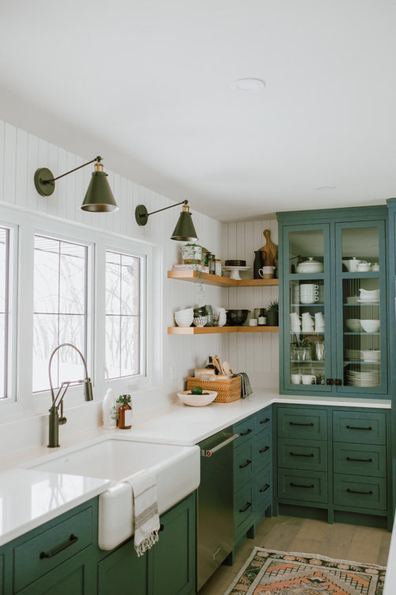 kitchen space with green cabinets and two light fixtures