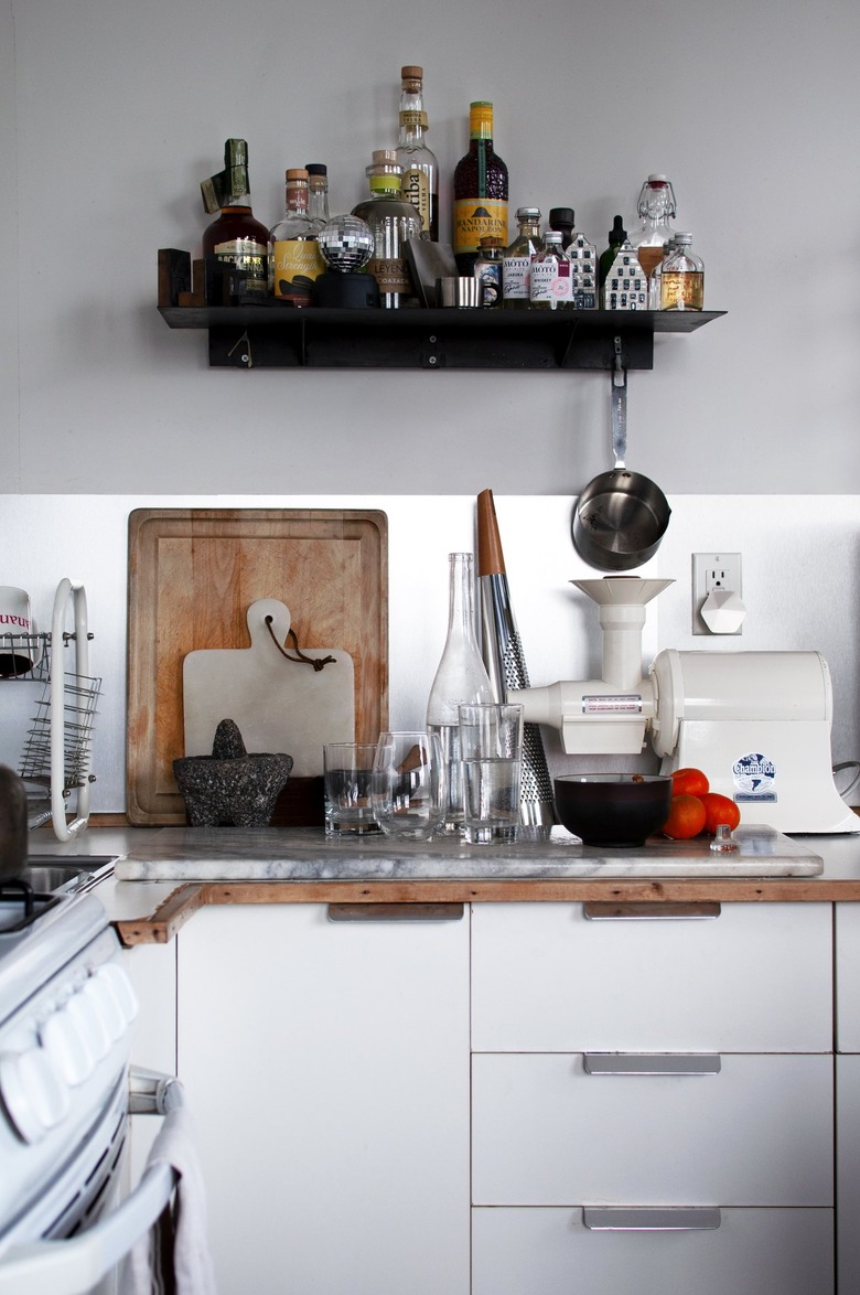 A kitchen with white cabinets, appliances and dishware