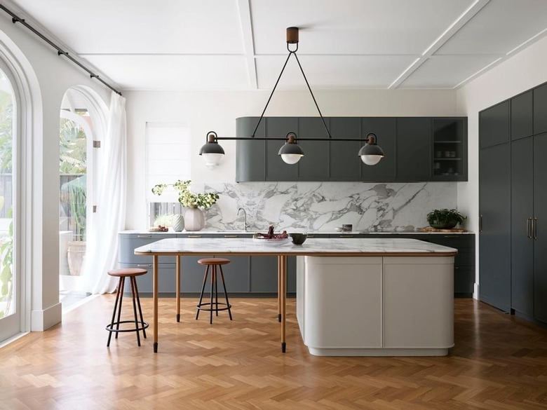 modern gray and white kitchen with marble backsplash and wood flooring