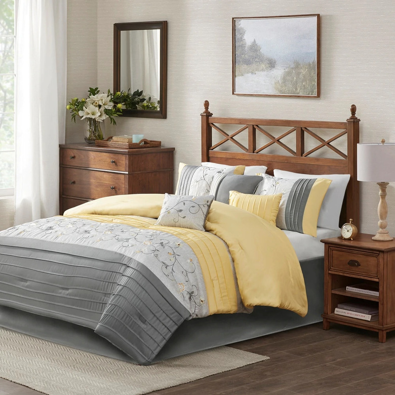 bedroom with gray and yellow bedding and white curtains