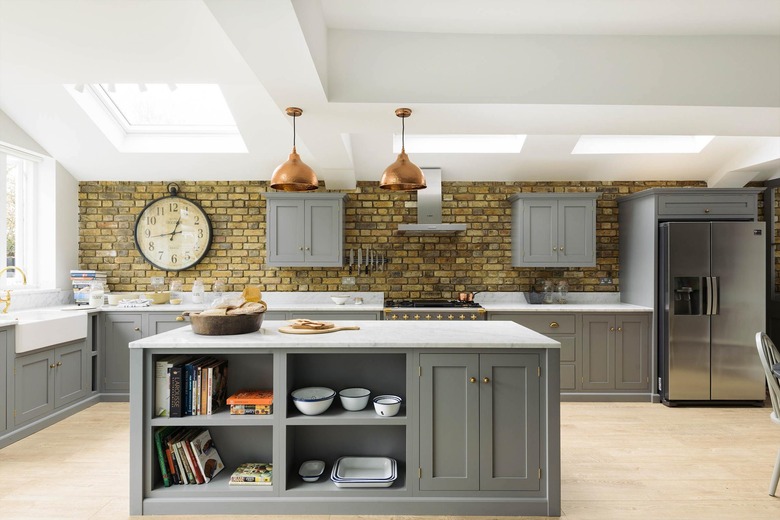 wooden gray kitchen island with open and closed storage and copper ceiling lights