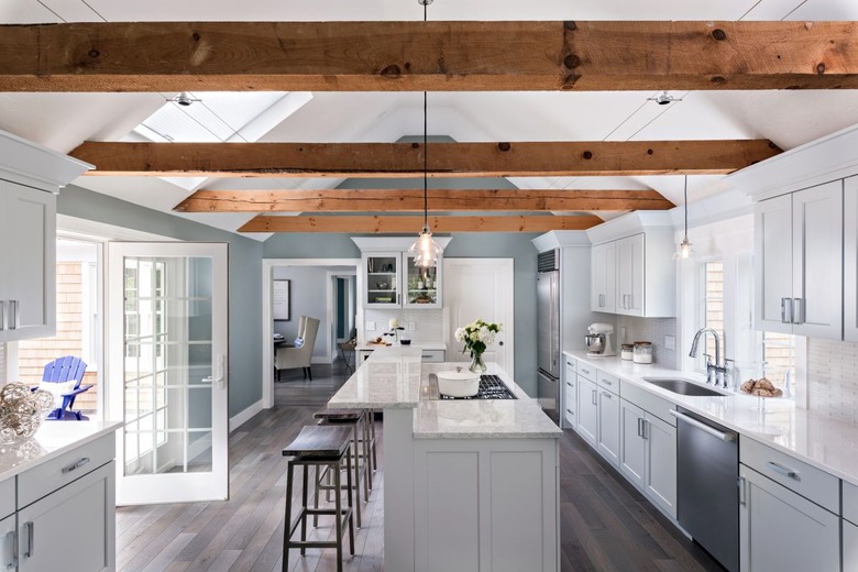 wooden gray kitchen island with additional ledge and reclaimed wood ceiling beams