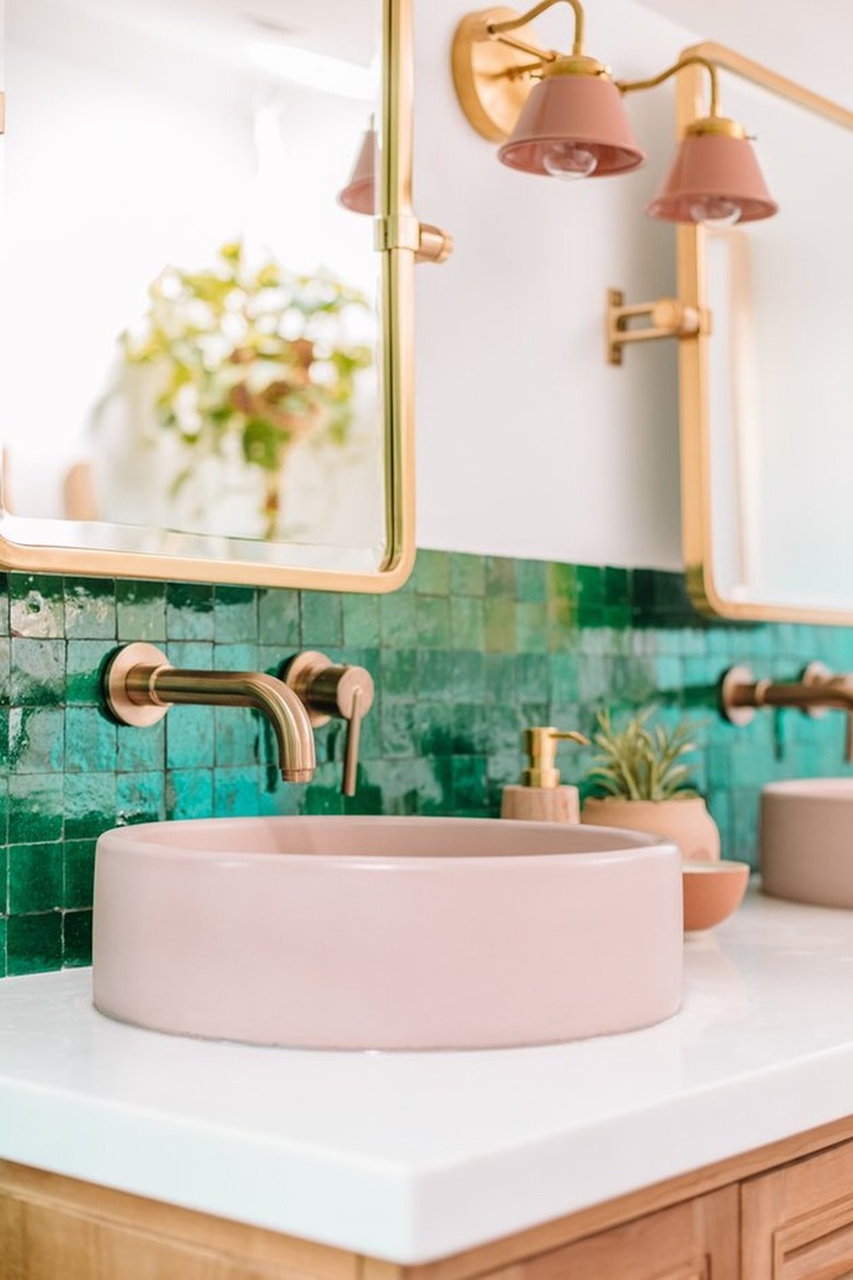 Pink vessel sink, green mosaic backplash, brass faucets.