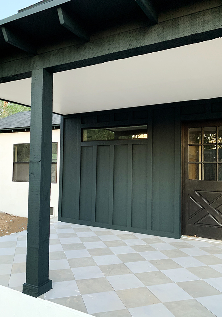 Dark forest green exterior house paint with checkered floor and black front door