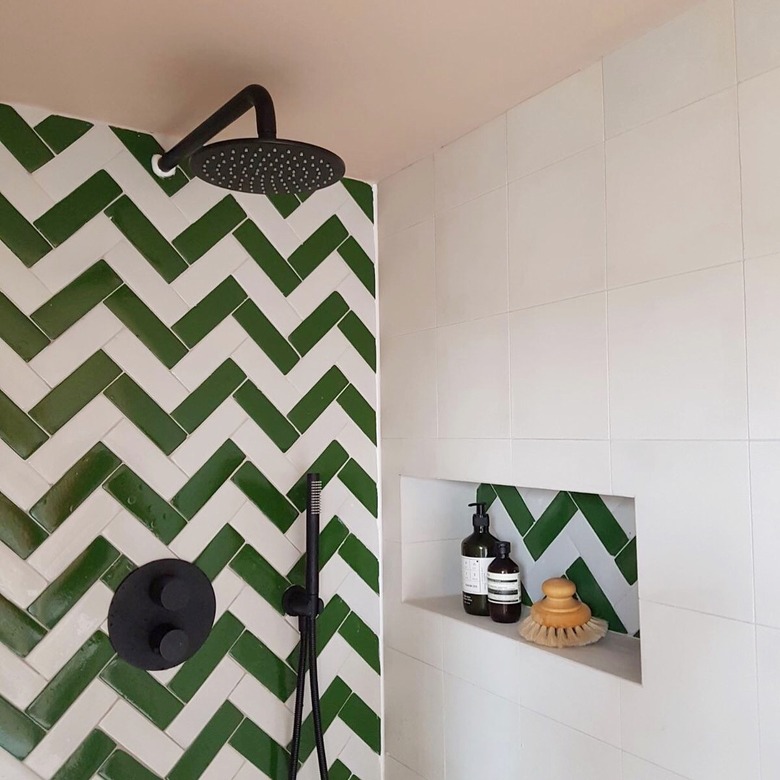 Green tile shower with green and white herringbone stripes