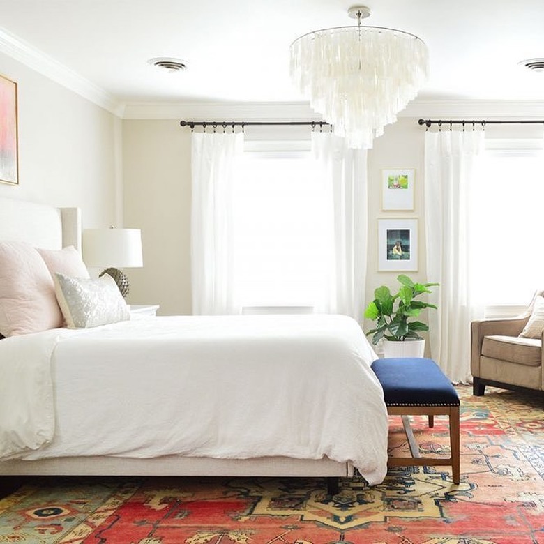 neutral bedroom color idea with  capiz chandelier and bold patterned rug