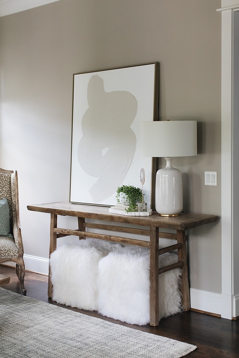 living room color idea with greige artwork and fluffy pouffes