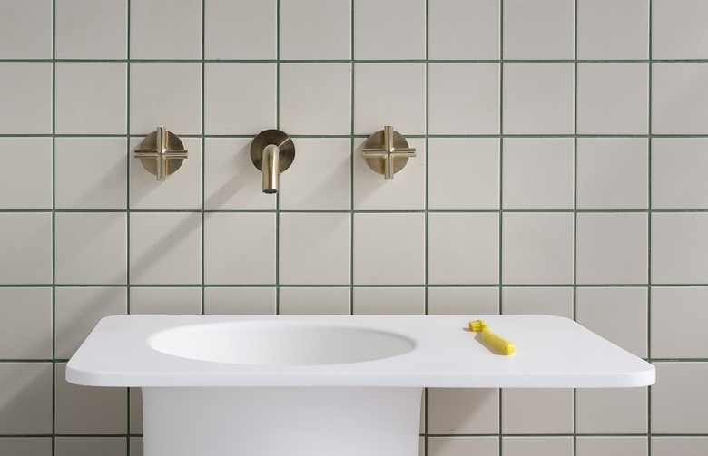 bathroom backsplash with white tile and green grout