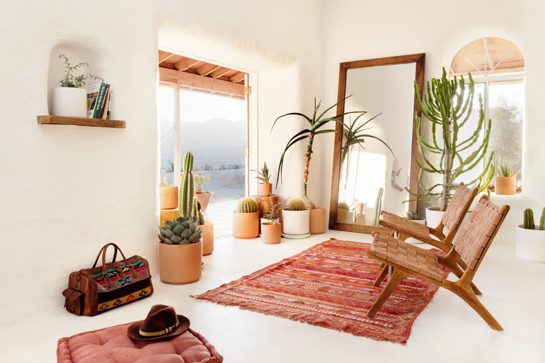 Color idea in boho sitting room with woven leather chairs and red accessories