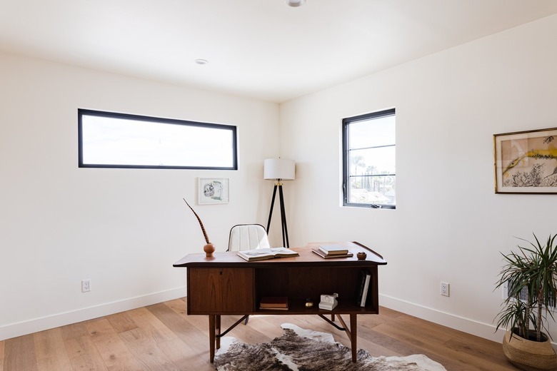 home office with midcentury wood desk and floor lamp with swivel chair