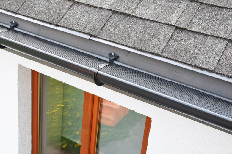 Plastic guard over new dark grey plastic rain gutter