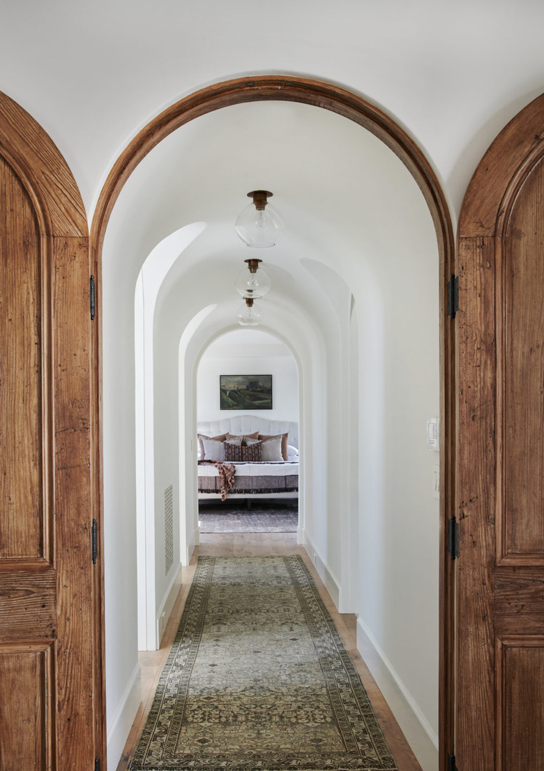 Endless arches and a long runner make this hallway seem infinite.