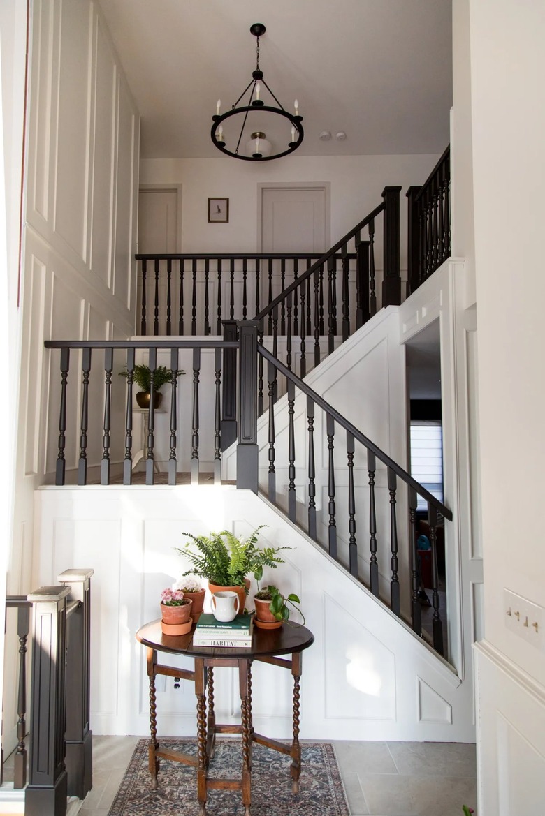 traditional staircase with vintage table in entryway